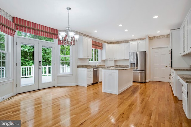 5257 Ferry Branch Ln, Lothian, MD 20711 - kitchen with stainless steel appliances, a kitchen island, white cabinetry, a chandelier, and hanging light fixtures