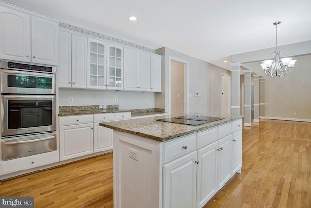 5257 Ferry Branch Ln, Lothian, MD 20711 - kitchen with a warming drawer, black electric stovetop, stainless steel double oven, light wood-type flooring, and a center island