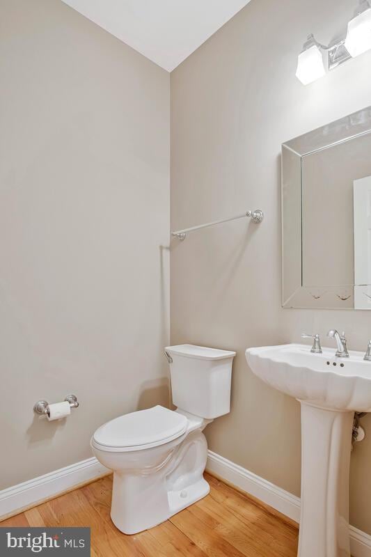5257 Ferry Branch Ln, Lothian, MD 20711 - half bathroom with toilet, baseboards, wood finished floors, and a sink