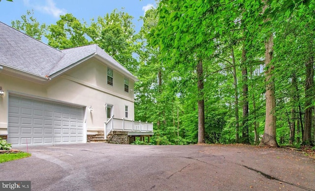5257 Ferry Branch Ln, Lothian, MD 20711 - view of side of property featuring a shingled roof, stucco siding, driveway, and an attached garage
