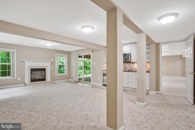 5257 Ferry Branch Ln, Lothian, MD 20711 - unfurnished living room with light carpet, baseboards, and a glass covered fireplace