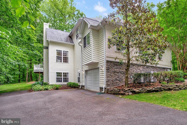 5257 Ferry Branch Ln, Lothian, MD 20711 - view of home's exterior featuring a chimney, stone siding, asphalt driveway, and an attached garage