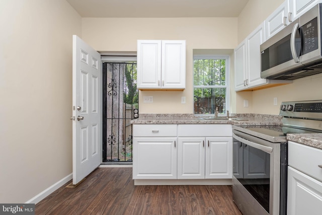 1839 Ramsay St, Baltimore, MD 21223 - kitchen with appliances with stainless steel finishes, dark wood-type flooring, white cabinetry, and baseboards