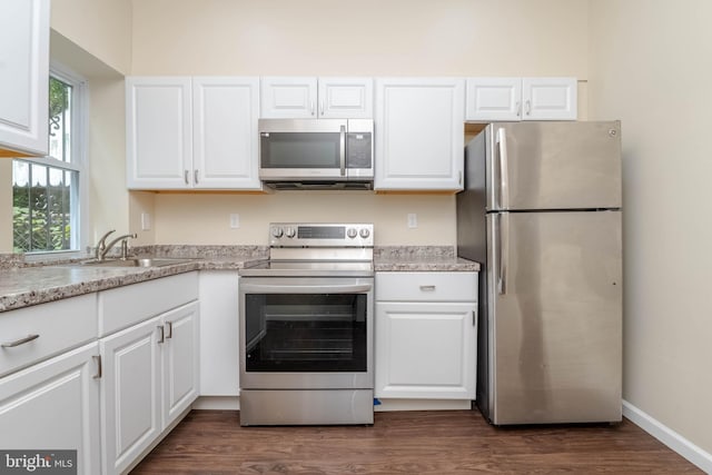 1839 Ramsay St, Baltimore, MD 21223 - kitchen with appliances with stainless steel finishes, white cabinetry, a sink, and dark wood-type flooring