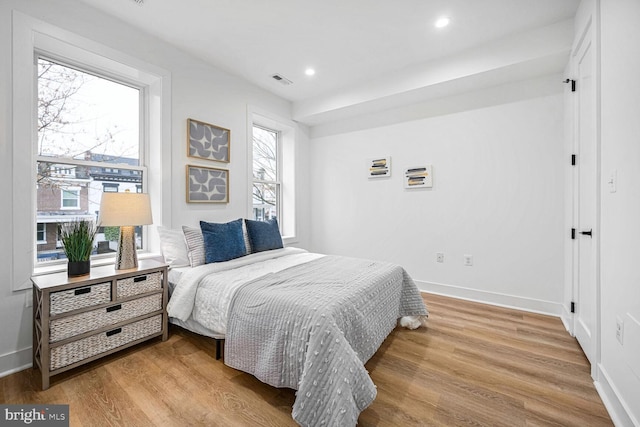 bedroom with wood finished floors, baseboards, and recessed lighting