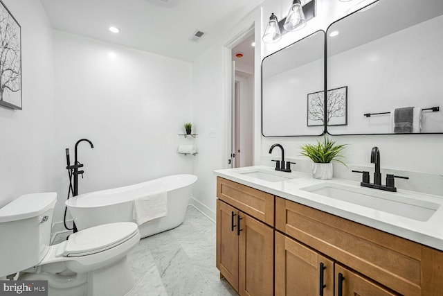 bathroom featuring marble finish flooring, toilet, a freestanding tub, double vanity, and recessed lighting