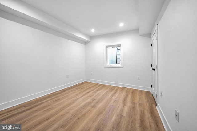 empty room featuring recessed lighting, wood finished floors, and baseboards