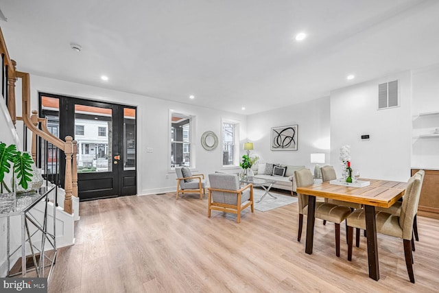 dining space with light wood-type flooring, recessed lighting, and stairs