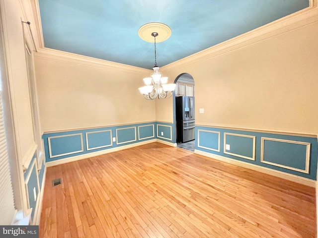 126 Greenway St, Fredericksburg, VA 22405 - spare room featuring a chandelier, arched walkways, wainscoting, light wood finished floors, and crown molding