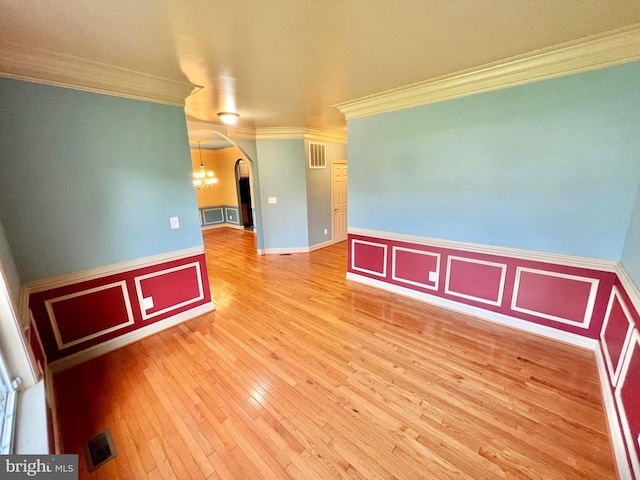 126 Greenway St, Fredericksburg, VA 22405 - unfurnished room featuring ornamental molding, arched walkways, a wainscoted wall, hardwood / wood-style flooring, and a chandelier