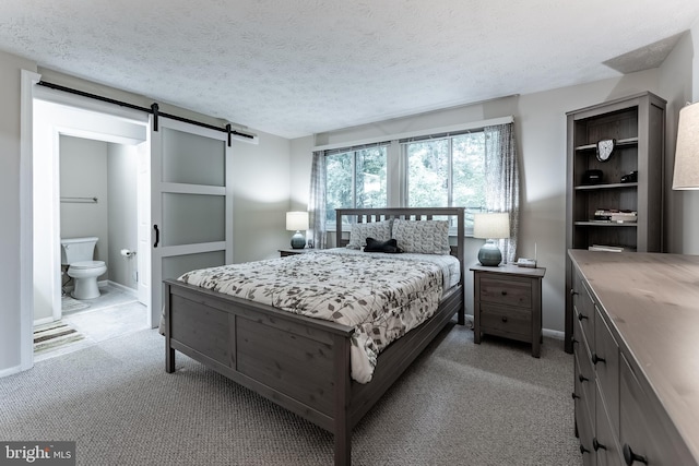 7414 Golden Horseshoe Ct, Springfield, VA 22153 - bedroom featuring a barn door, light carpet, a textured ceiling, and ensuite bath