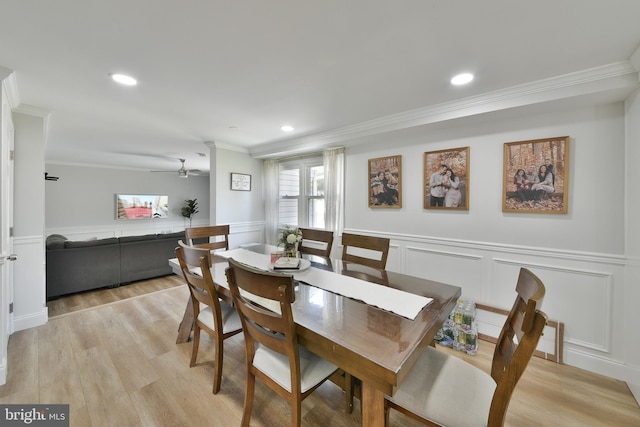 100 Shenandoah Rd, Cinnaminson, NJ 08077 - dining space with ornamental molding, a decorative wall, a ceiling fan, wainscoting, and light wood-style floors