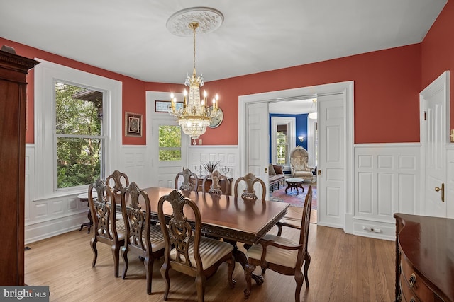 100 W Maple Ave, Merchantville, NJ 08109 - dining space with a wainscoted wall, a decorative wall, a chandelier, and light wood-style floors