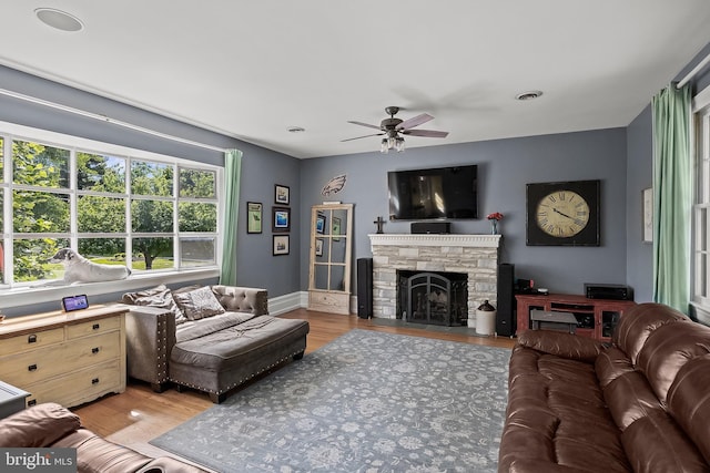 100 W Maple Ave, Merchantville, NJ 08109 - living area with a ceiling fan, light wood finished floors, a stone fireplace, and baseboards