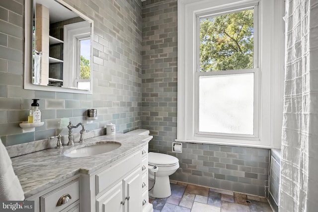 100 W Maple Ave, Merchantville, NJ 08109 - bathroom featuring healthy amount of natural light, stone finish flooring, tile walls, vanity, and toilet
