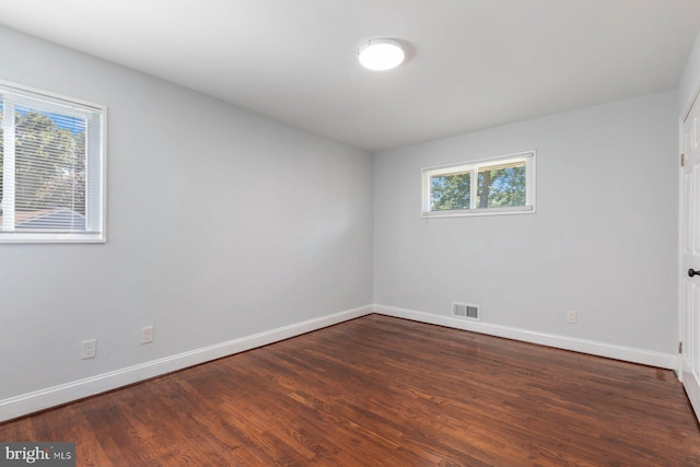 empty room featuring baseboards and wood finished floors