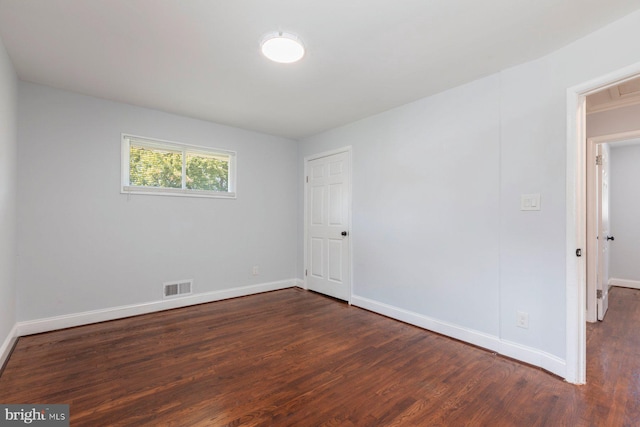 empty room with dark wood-style floors and baseboards