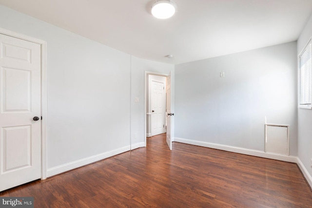 empty room featuring wood finished floors and baseboards