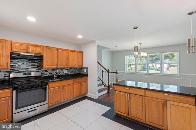 kitchen with stainless steel range with gas cooktop, under cabinet range hood, decorative backsplash, a sink, and a chandelier