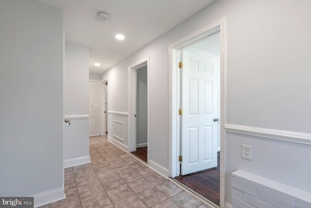 hallway featuring recessed lighting, light tile patterned floors, and baseboards