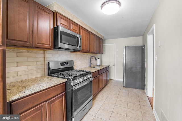 1243 Maple Ave, Wilmington, DE 19805 - kitchen with stainless steel appliances, tasteful backsplash, a sink, baseboards, and light stone counters