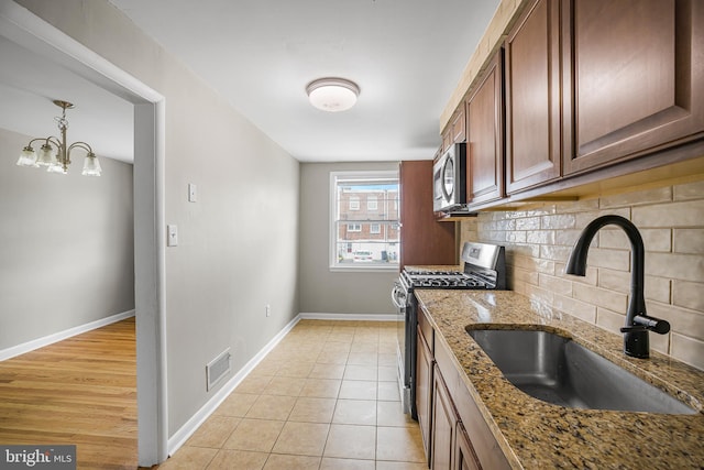 1243 Maple Ave, Wilmington, DE 19805 - kitchen with appliances with stainless steel finishes, a sink, decorative backsplash, baseboards, and light stone counters