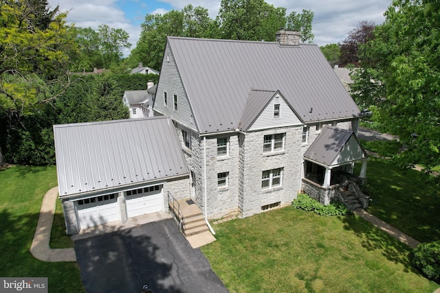441-445 Ridge Ave, State College, PA 16803 - view of front of house featuring a chimney, stone siding, metal roof, a front yard, and an attached garage