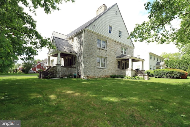 441-445 Ridge Ave, State College, PA 16803 - back of house with stone siding, a yard, a chimney, and metal roof