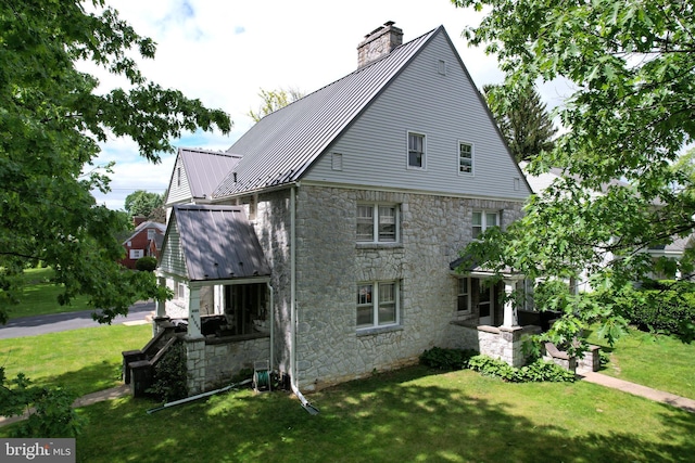 441-445 Ridge Ave, State College, PA 16803 - view of side of property with stone siding, a chimney, a lawn, and metal roof