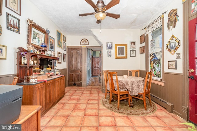 135 Lucknow Rd, Harrisburg, PA 17110 - dining room with a wainscoted wall, ceiling fan, a baseboard heating unit, a textured ceiling, and wooden walls