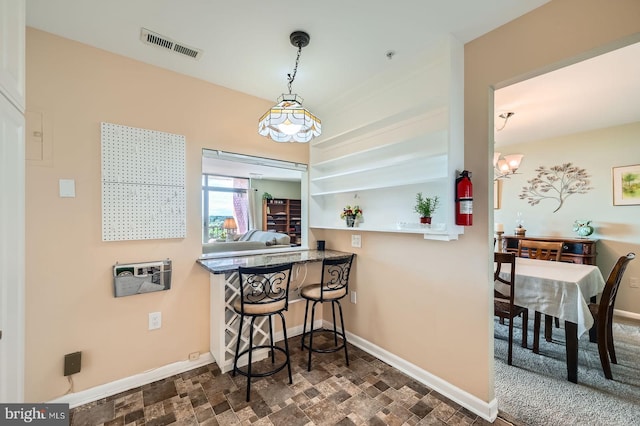1 Smeton Pl Unit 1004, Towson, MD 21204 - kitchen featuring baseboards, stone finish flooring, a kitchen bar, and decorative light fixtures
