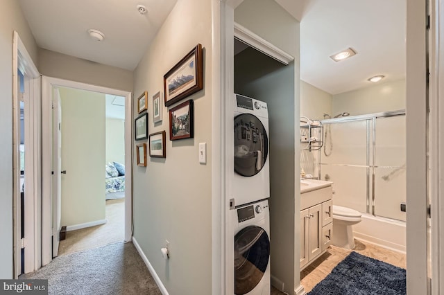 1 Smeton Pl Unit 1004, Towson, MD 21204 - laundry area featuring stacked washer / drying machine, light carpet, and baseboards