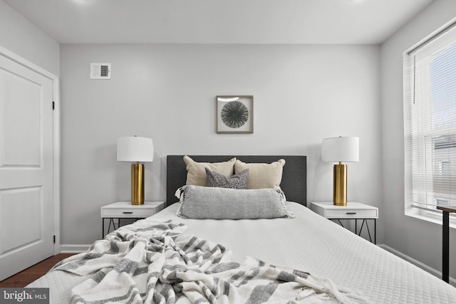 510 N Glover St, Baltimore, MD 21205 - bedroom featuring multiple windows, dark wood-style floors, and baseboards