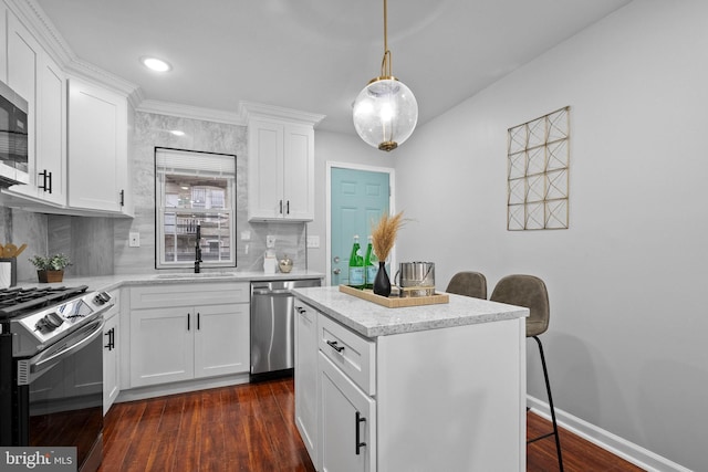 510 N Glover St, Baltimore, MD 21205 - kitchen featuring stainless steel appliances, a sink, tasteful backsplash, a center island, and white cabinets