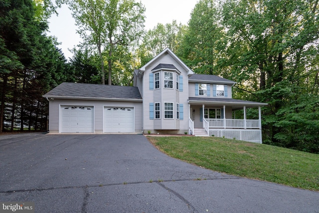 1451 Apple, Saint Leonard, MD 20685 - view of front facade featuring asphalt driveway, a garage, a porch, a front lawn, and view of scattered trees