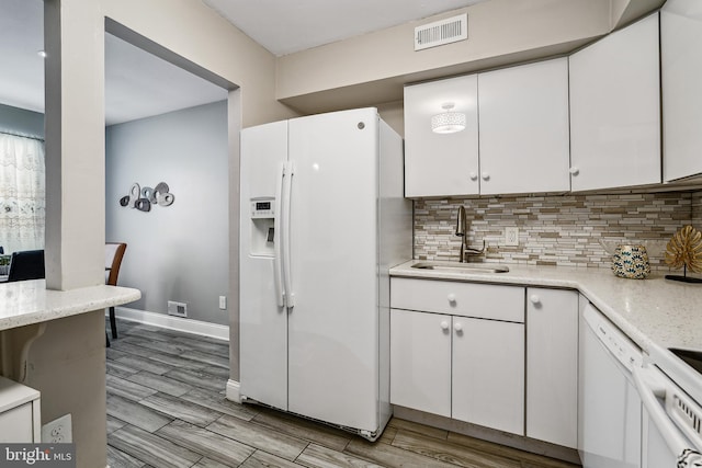 205 Highland Blvd, New Castle, DE 19720 - kitchen featuring white appliances, a sink, white cabinetry, decorative backsplash, and baseboards
