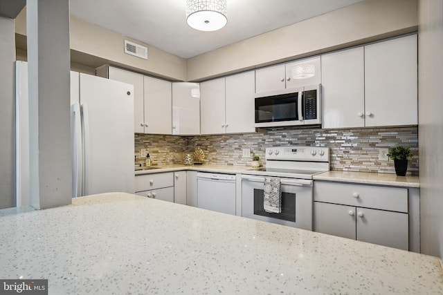 205 Highland Blvd, New Castle, DE 19720 - kitchen with white appliances, white cabinetry, and decorative backsplash