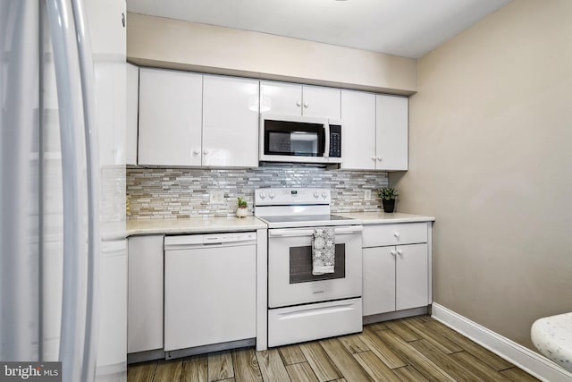 205 Highland Blvd, New Castle, DE 19720 - kitchen with white appliances, white cabinetry, tasteful backsplash, light countertops, and light wood-style flooring