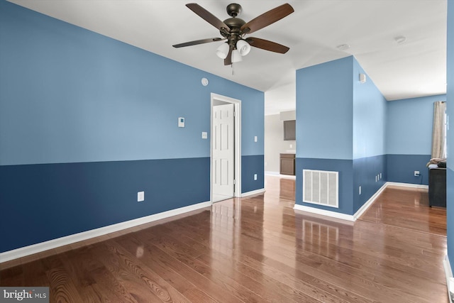 empty room with ceiling fan, wood finished floors, and baseboards