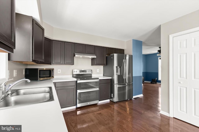 kitchen with stainless steel appliances, a sink, a ceiling fan, dark wood-style floors, and light countertops