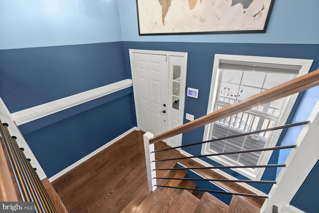 stairs with wood finished floors and baseboards