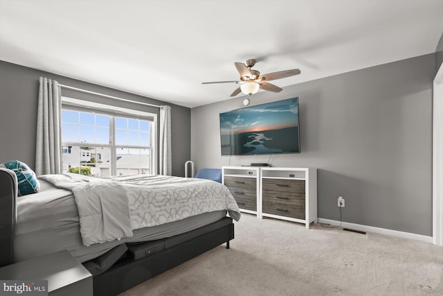 carpeted bedroom featuring baseboards and ceiling fan