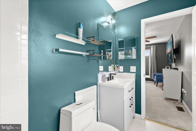 bathroom featuring vanity, ceiling fan, toilet, and baseboards