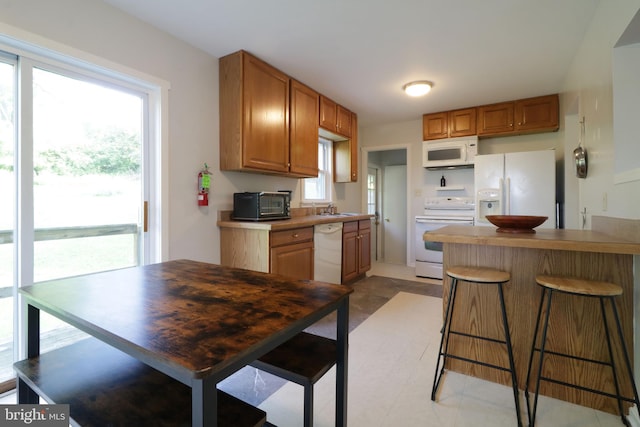 250 E Main St, Millheim, PA 16854 - kitchen featuring white appliances, plenty of natural light, a kitchen bar, and a sink
