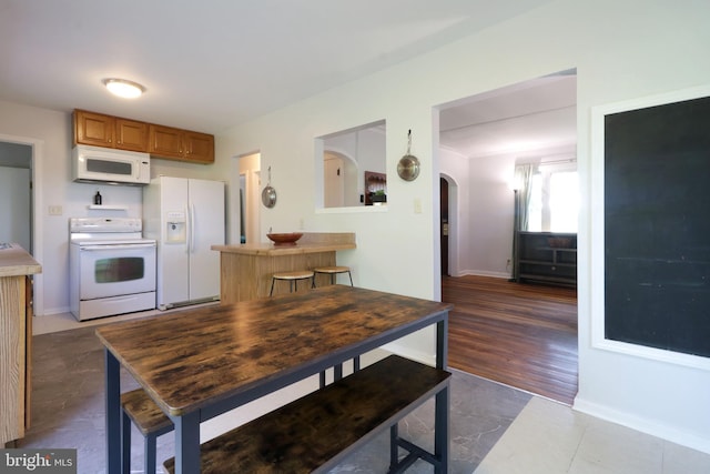 250 E Main St, Millheim, PA 16854 - kitchen with white appliances, baseboards, and arched walkways