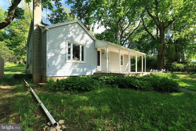 250 E Main St, Millheim, PA 16854 - view of front facade with covered porch, a chimney, and a front lawn