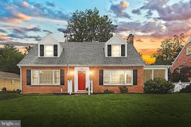 1522 Hollywood Pkwy, York, PA 17403 - cape cod house featuring brick siding, a chimney, a lawn, and a shingled roof