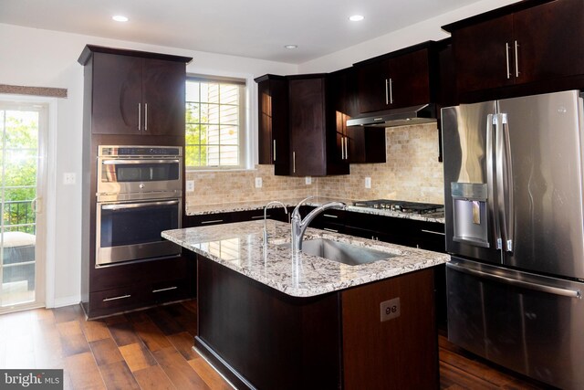 42624 Lisburn Chase Ter, Chantilly, VA 20152 - kitchen with appliances with stainless steel finishes, under cabinet range hood, dark wood finished floors, a sink, and backsplash