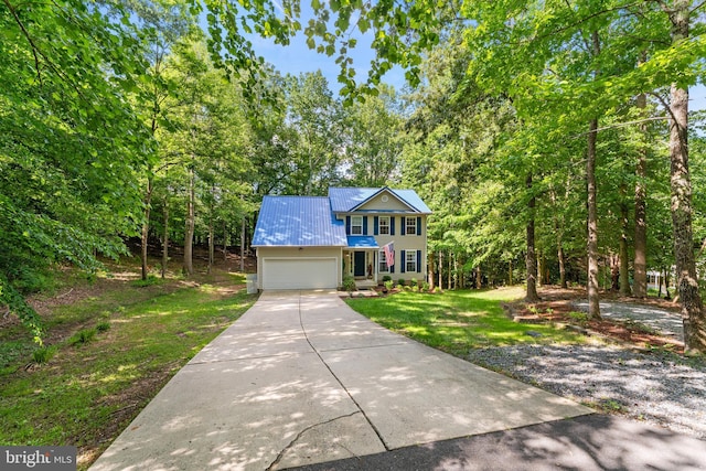 9380 Caucus Dr, King George, VA 22485 - view of front facade with an attached garage, concrete driveway, metal roof, and a front yard