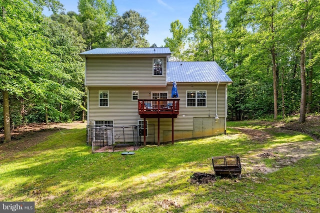 9380 Caucus Dr, King George, VA 22485 - rear view of house with metal roof, a wooden deck, and a yard